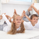 Family doing stretching exercises laying on the floor - healthy lifestyle